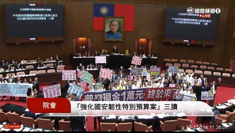 立法院三讀通過《因應國際情勢強化經濟社會及民生國安韌性特別條例》,普發現金1萬元終於拍板,國民黨(右區)與民眾黨(左區)立委們在議場舉牌歡呼。(圖/國會頻道)