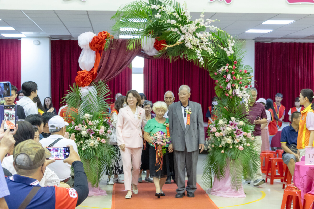 ▲屏東市公所今(19)日辦理「屏東市114年模範夫妻表揚典禮」,祝賀17對結婚滿60年以上之佳偶,市長周佳琪陪同出席典禮婚齡最長的模範夫妻—陳豐治與張香惠伉儷一同步上紅毯進場。(圖/屏東市公所提供)