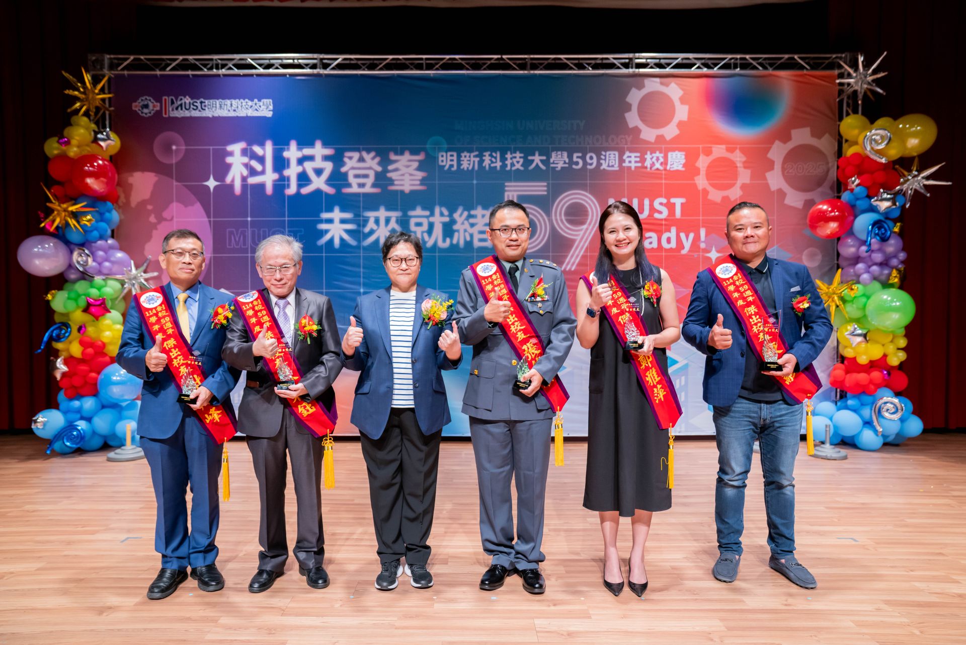 明新科技大學頒發「傑出校友獎」，由董事長郝碧蓮親自表揚五位獲獎校友。左起為電子科謝戎峰、管研所蘇東鈺、郝碧蓮董事長、電子科張然順、幼保系鄭雅萍與旅館系廖俊融，展現明新人在產業、教育、公務與創新領域的卓越成就。
