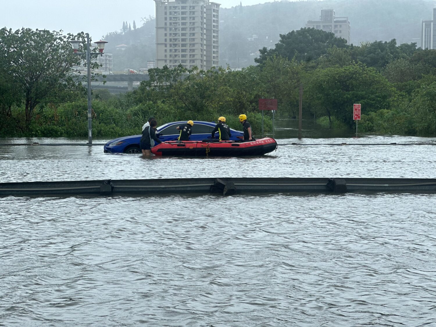 民眾車輛受困積水中，消防橡皮艇救援中。(記者李健興翻攝)