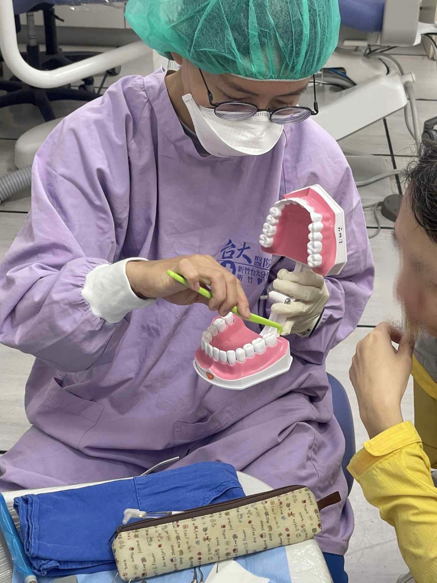 莊雅淳醫師示範正確刷牙方式，提醒民眾將刷毛斜向牙齦溝，輕柔來回刷。