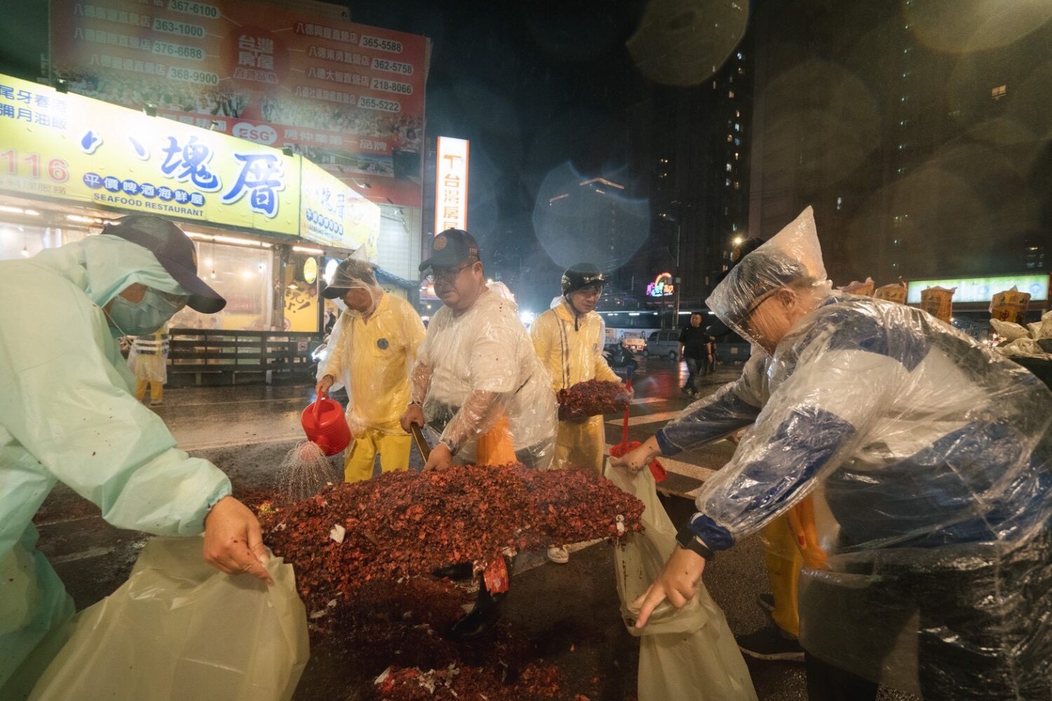 大雨加深路面清掃難度,但志工們用力剷鞭炮餘灰維持香路ESG。(圖/桃園護國宮提供)