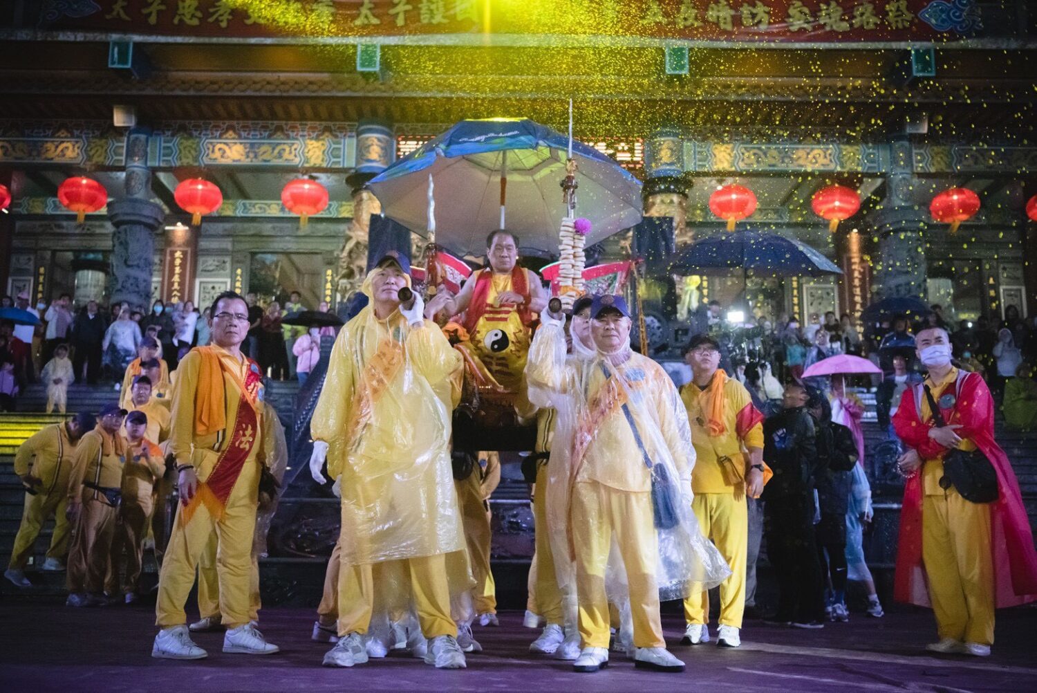 桃園護國宮太子爺「五夜暗訪」風雨中回鑾,太子爺在閱兵台上陣頭一一參禮,頭家們和貴賓扛著釘椅恭迎聖駕。(圖/桃園護國宮提供)