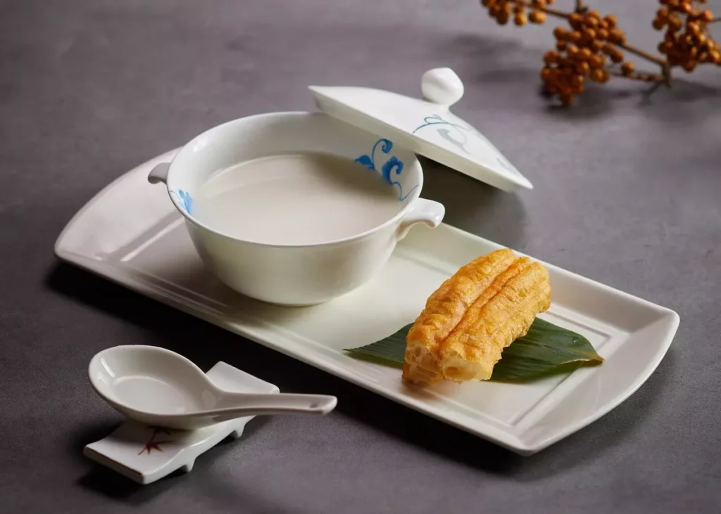 油條杏仁茶以南、北杏仁細磨熬煮,融合花生的濃郁香氣,搭配外酥內軟的現炸油條,浸入杏仁茶中一同享用,是老台北味最經典的甜品之一。圖/圓山大飯店提供