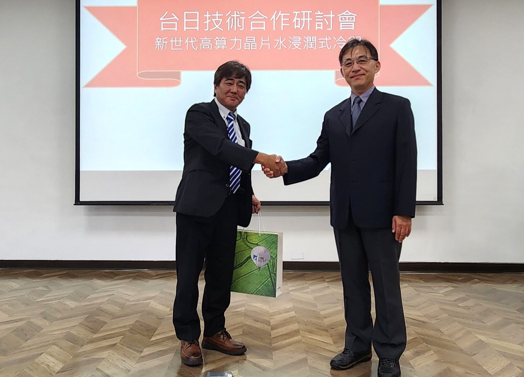工研院與日本新創公司ZYRQ展開策略合作,共同開發新世代「水浸潤式冷卻技術」,以環保、節能與高效能為核心目標,解決AI晶片高功耗造成的散熱瓶頸。左起為日本ZYRQ社長長井大、工研院機械所副所長楊秉祥。