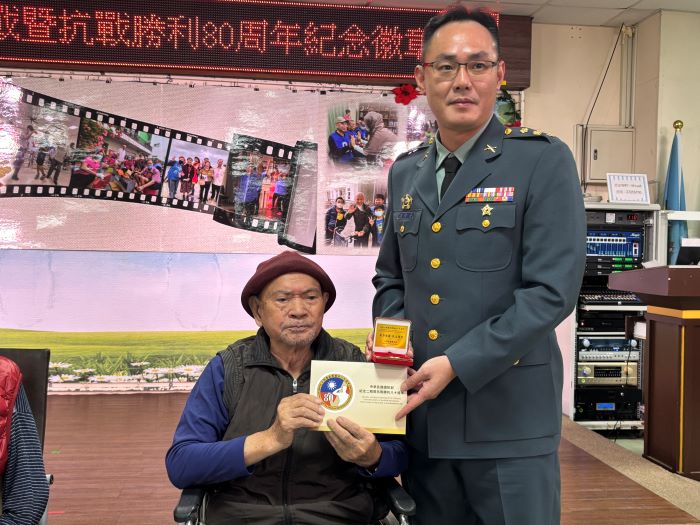 板橋榮家抗戰英雄獲頒國防部80周年紀念徽章 13 《圖說》新北後指部指揮官溫俊晏(右)頒贈紀念章給板橋榮家譚伯伯。〈板橋榮家提供〉