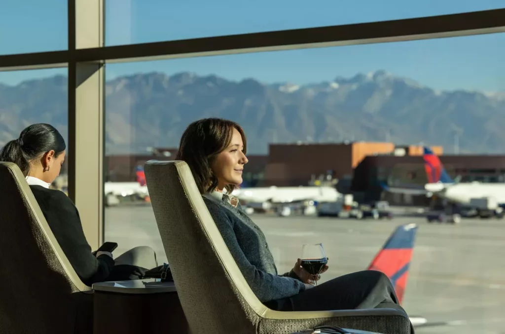 旅客在達美飛凡貴賓室（Delta Sky Club）享受靜謐氛圍與窗外山景，展現休閒與商務並重的貼心設計