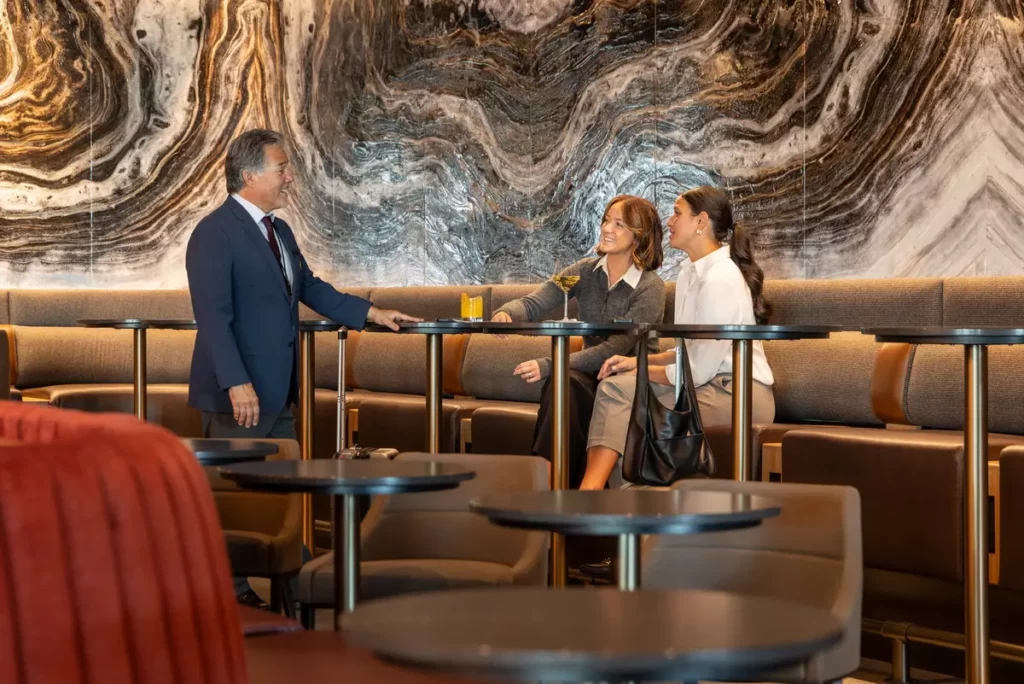 旅客在達美飛凡貴賓室（Delta Sky Club）享用飲品與交流時光，背景設計靈感源自猶他自然地景