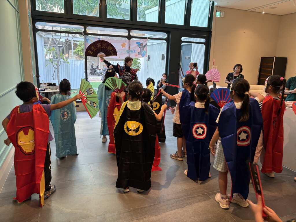 ▲川劇變臉師教導孩子們表演的身段。