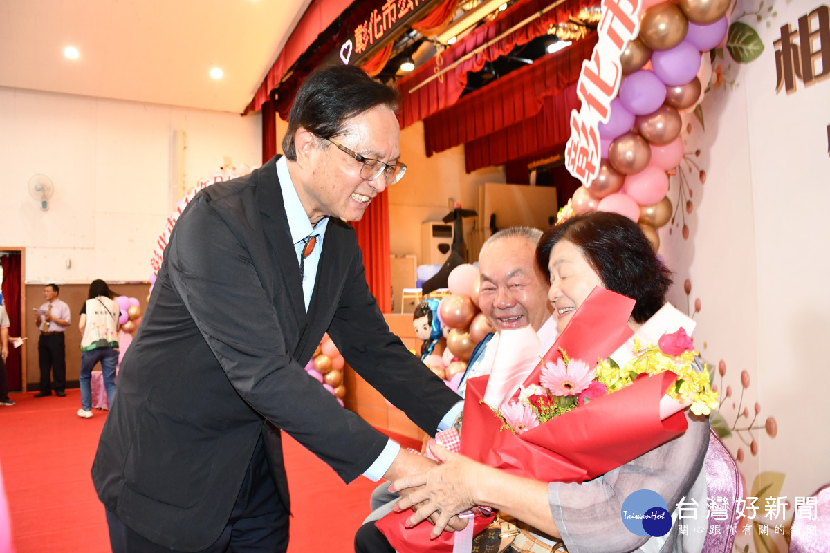 林世賢市長逐一贈花給結婚滿50年接受表揚的金婚夫婦。圖／彰化市公所提供
