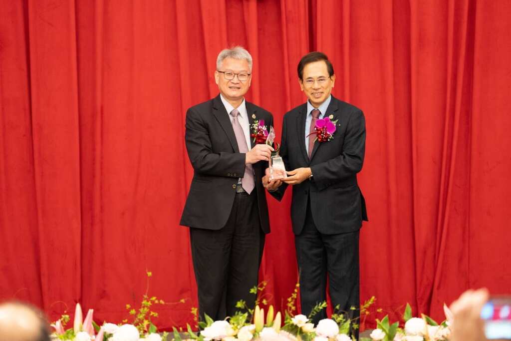 ▲中山醫大於65週年校慶頒授吳元煌名譽博士學位，由同窗邱文達(右)代為領取，左為校長黃建寧。（圖／中山醫大提供）