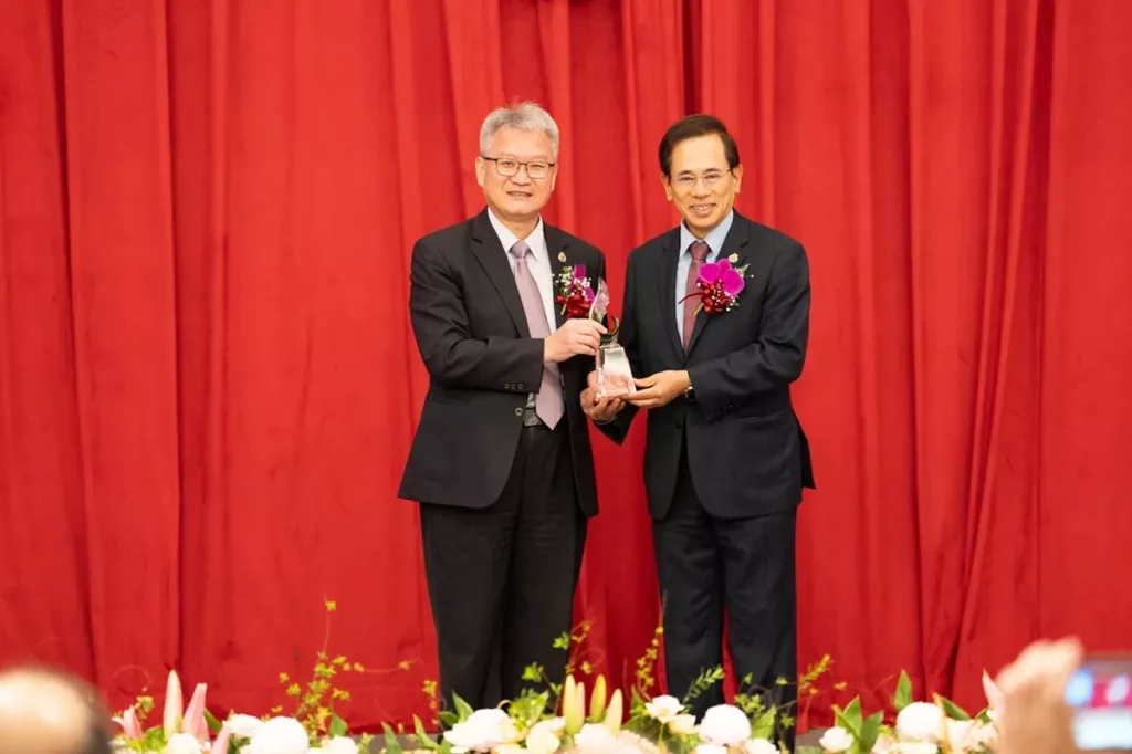 中山醫大於65週年校慶頒授吳元煌名譽博士學位,由同窗邱文達(右)代為領取,左為校長黃建寧。(圖/中山醫大提供)