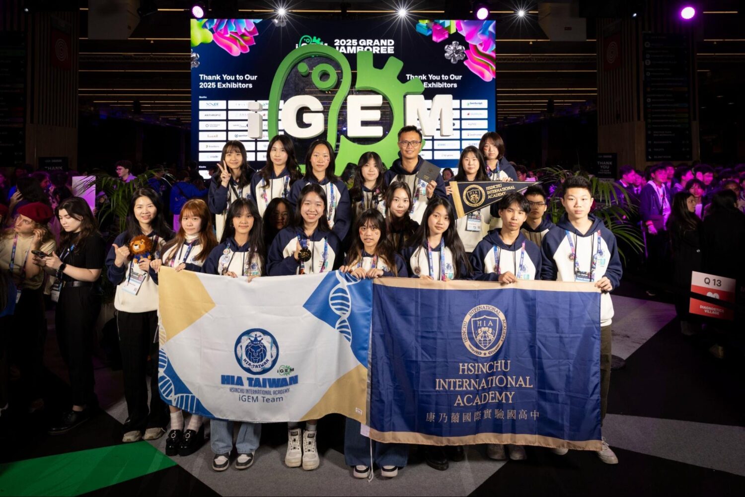 HIA-Taiwan 團隊於 2025 iGEM Grand Jamboree 榮獲金牌後合影留念,舉起校旗象徵榮耀與團隊精神,為臺灣教育與科研再添光采。(圖/記者張家燁翻攝)
