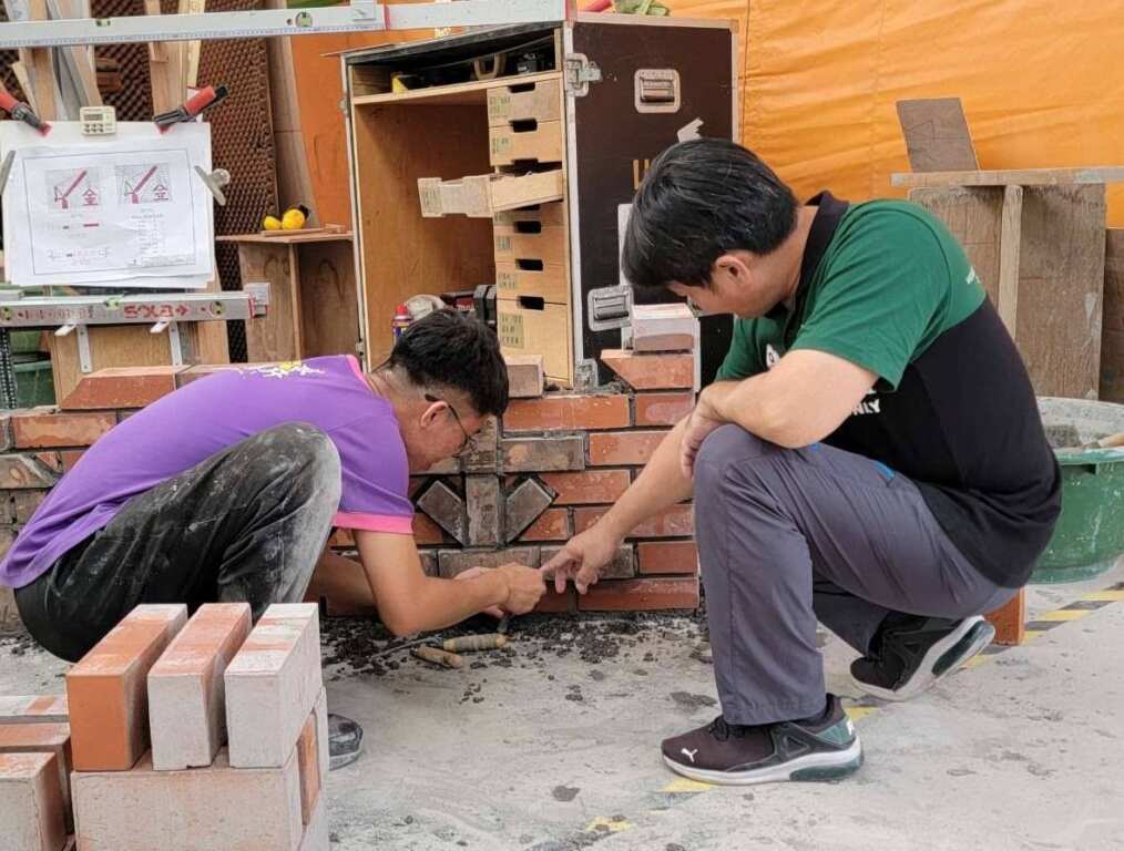 ▲中彰投分署訓練師邱耀慶指導勝華砌磚施作技巧。（圖／中彰投分署提供）
