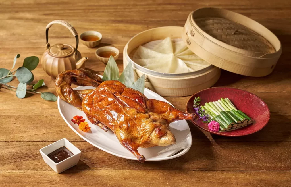 四人饗鴨宴主打紅樓片皮鴨二吃，片鴨皮酥肉嫩、香氣濃厚，醬爆鴨骨鹹香微辣，展現經典中式風韻。(瀚寓酒店提供)