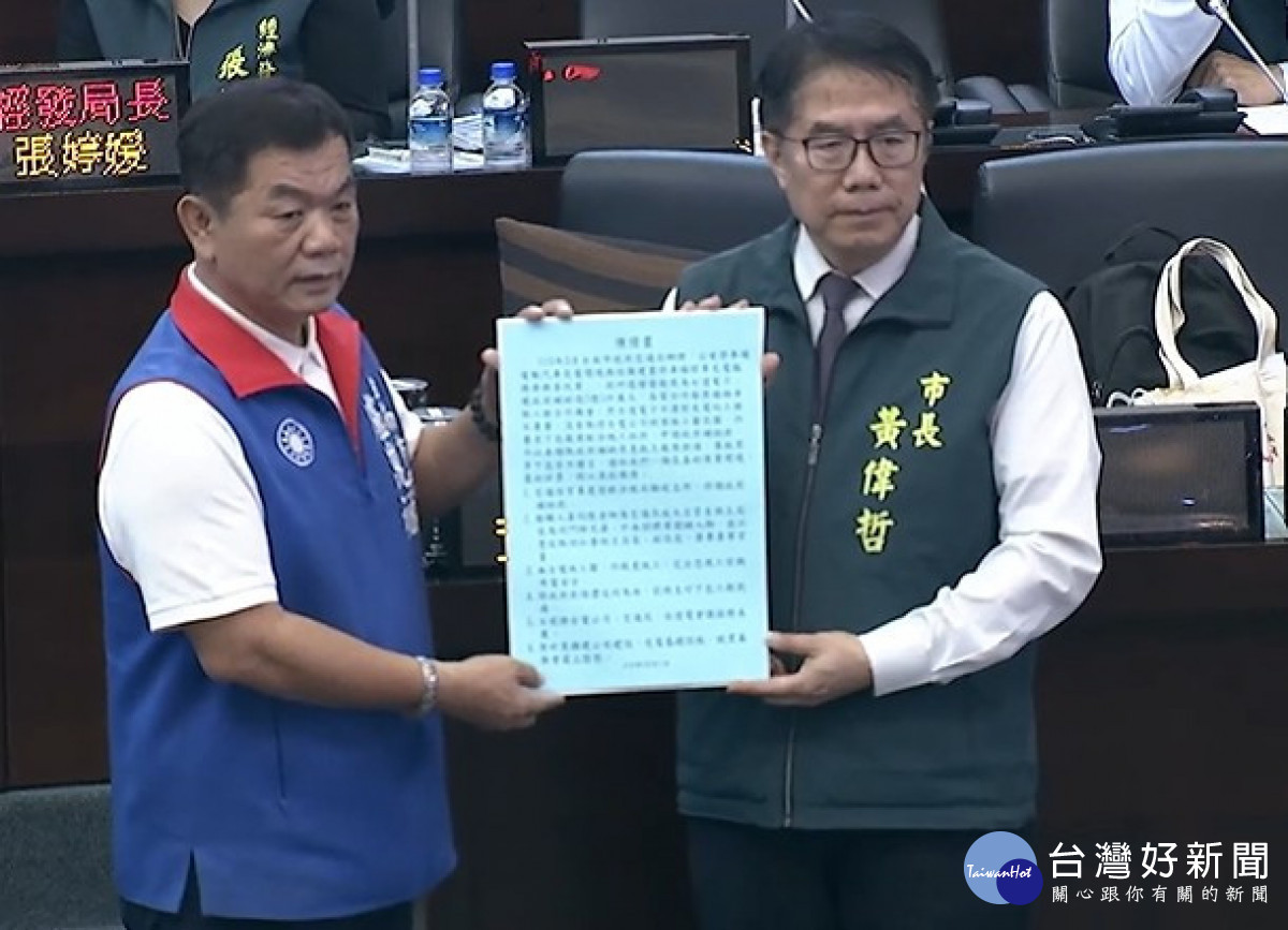 台南市議員盧崑福（左）趁總質詢時遞交民眾檢舉函給台南市長黃偉哲（右），要求政風、法制等單位嚴懲不法。