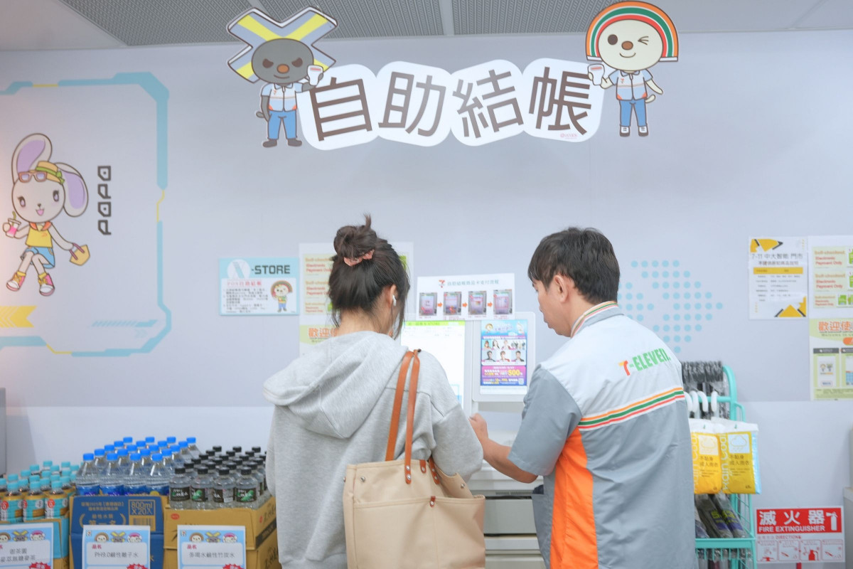 營運首日,7-ELEVEN X-STORE 9 店長貼心為學子說明自動結帳服務。<br /><br /> <br /><br />