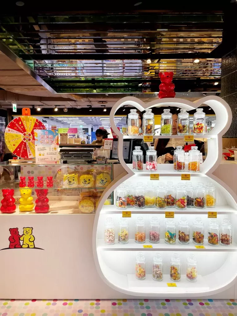 整體空間以繽紛的果汁軟糖色調為主視覺,搭配紅色小熊作為櫃上招牌形象,宛如被甜蜜糖果包圍的派對現場。