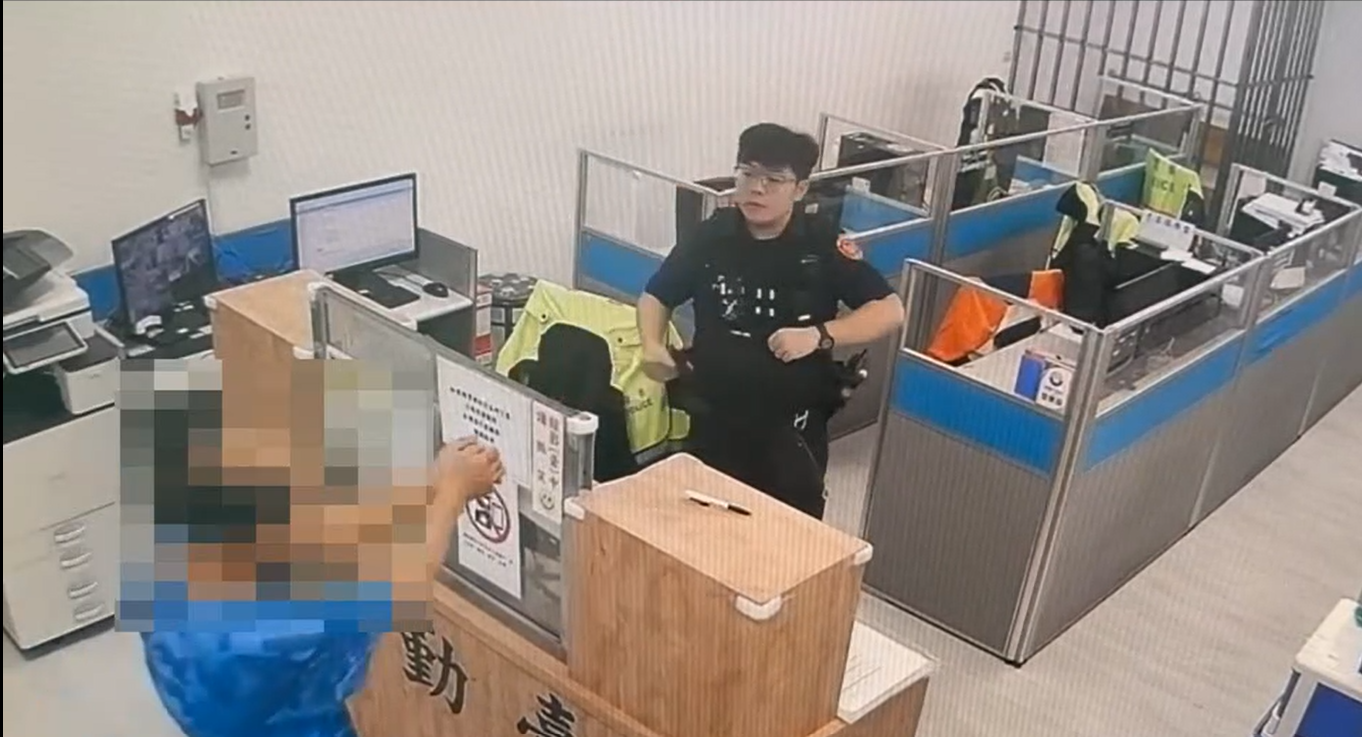 李男涉嫌殺害56歲妻子羅女,並於17日前往內壢派出所自首。到達警局後他主動將雙手靠攏、示意警員上銬。(記者翻攝)