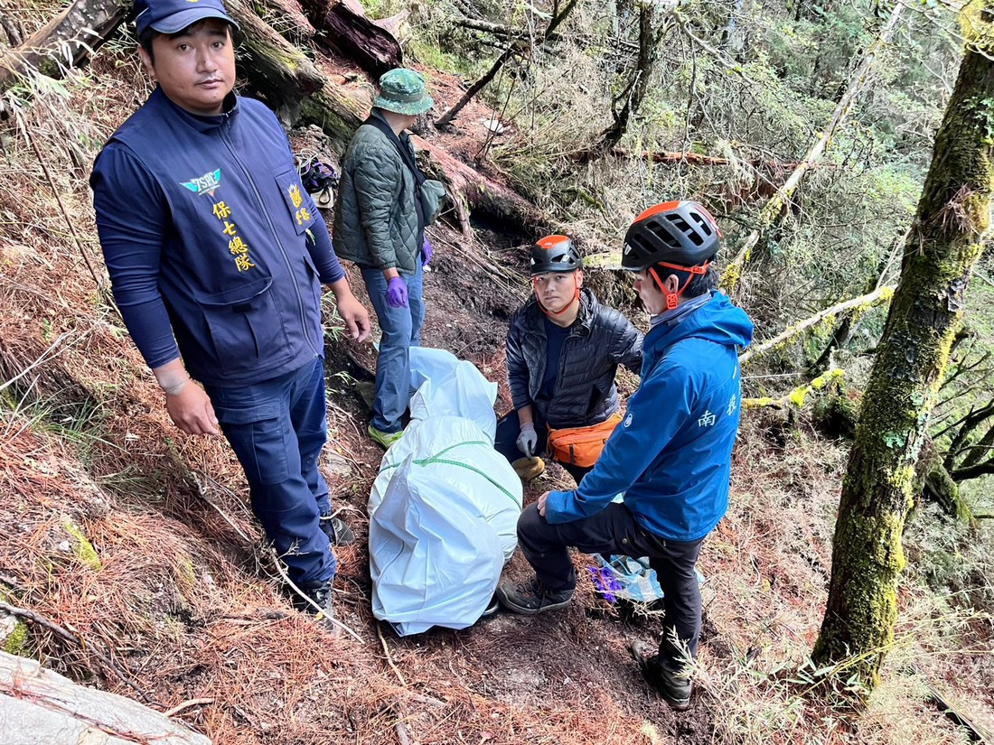 將罹難者打包以人力輪流揹負的方式穿越險峻地勢，艱辛地搬運。（南投縣政府消防局提供）