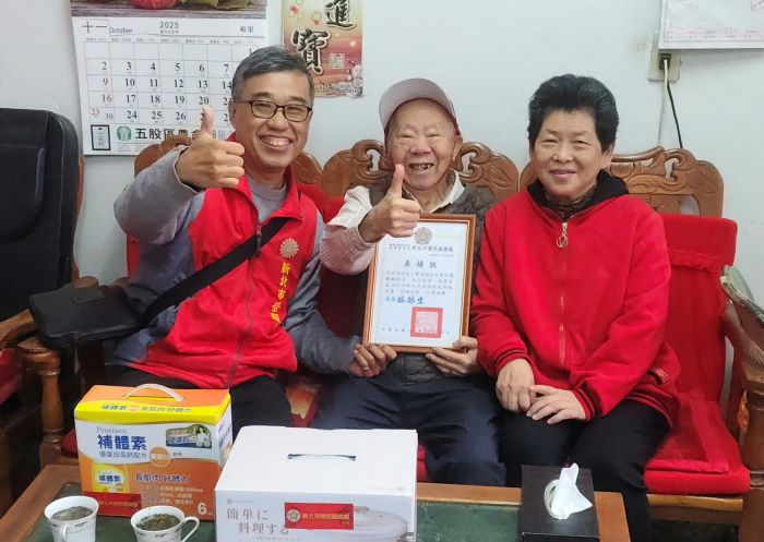 關懷五股區高齡榮民 新北榮服處寒天送暖到府 21 《圖說》新北市榮服處副處長李毓錫(左)轉頒尹伯伯夫婦新北榮 114 年「新住民生活家庭表揚」夫妻獎狀,並關心兩人生活近況。〈新北榮服處提供〉