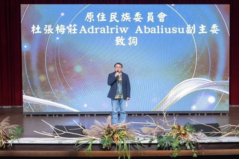 可能是顯示的文字是「原住民族委員會 杜張梅莊AdralriwAbaliu 杜張梅莊A Adralriw Abaliusu iwAbaliusu副主委 副主委 致詞」的圖像