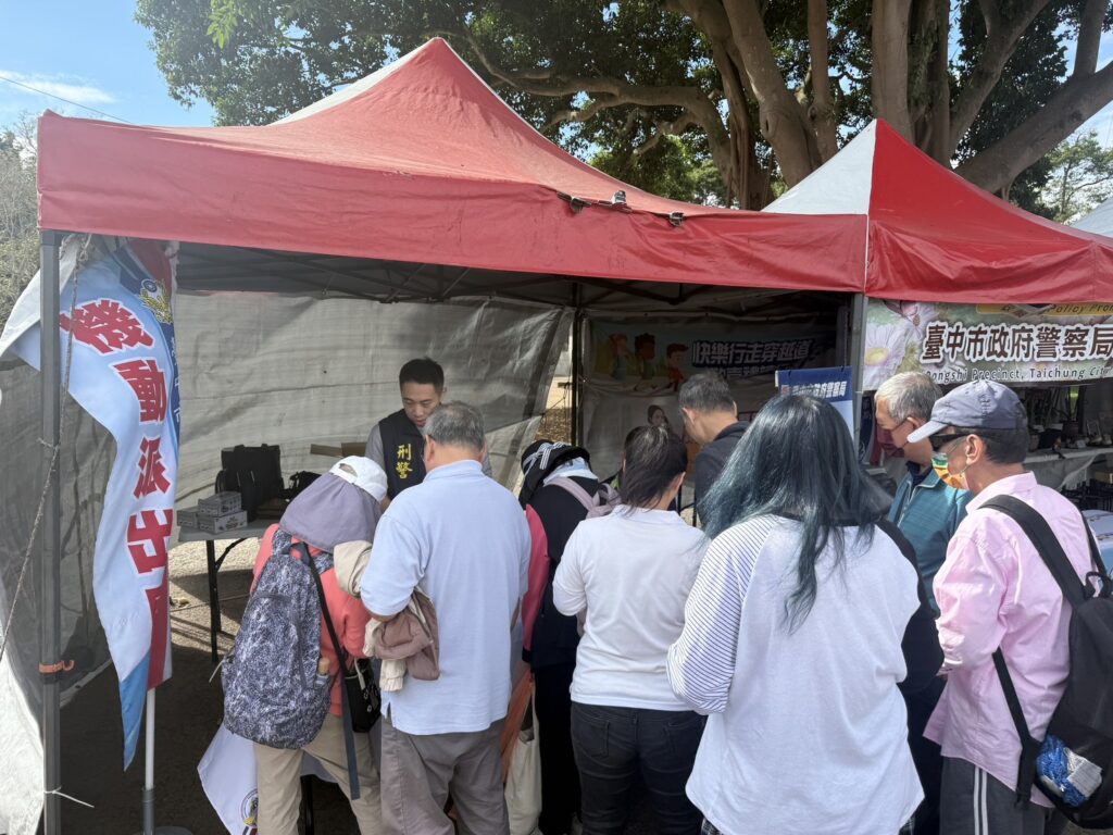 民眾在花毯節攤位前熱情參與識詐與預防犯罪宣導活動,現場互動相當踴躍。(圖/記者林家嘉翻攝)