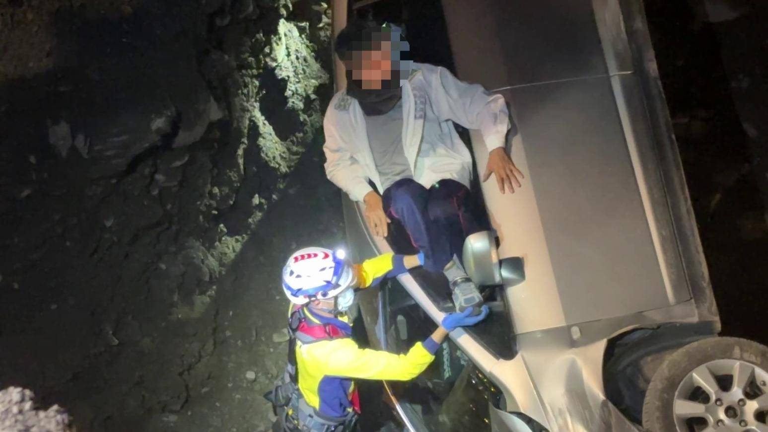 救援人員立即調派器材車,利用機械吊臂將受困於溪床的丈夫及妻子吊掛上岸