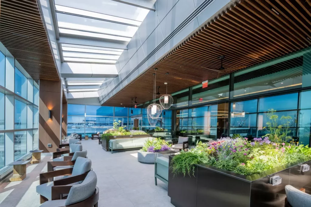 紐約 JFK 機場的達美至臻商務艙貴賓室(Delta One Lounge)設有露台花園,旅客可在自然光與季節植栽環境中欣賞跑道景色