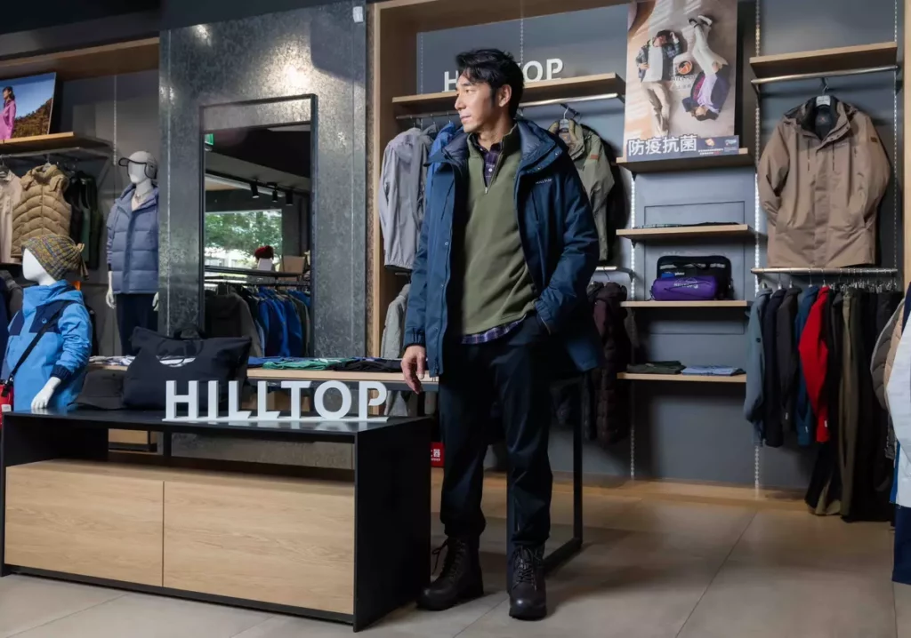 山頂鳥商務穿搭新品，內著為吸濕快乾保暖彈性長袖格子襯衫、中層POLARTEC®半開襟刷毛上衣、外層搭配GORE-TEX二合一防水石墨烯蓄熱羽絨長大衣，兼具保暖、防風與透氣機能。