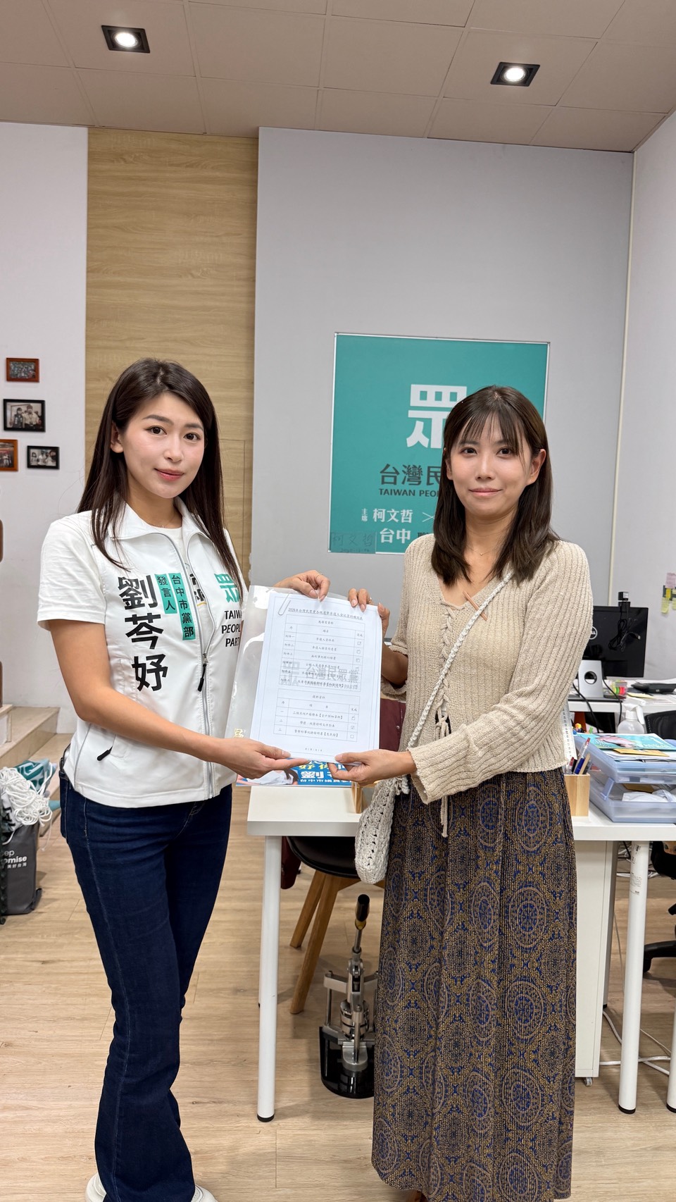 劉芩妤與民眾代表一同展示完成的登記資料，象徵地方參與與民主互動。