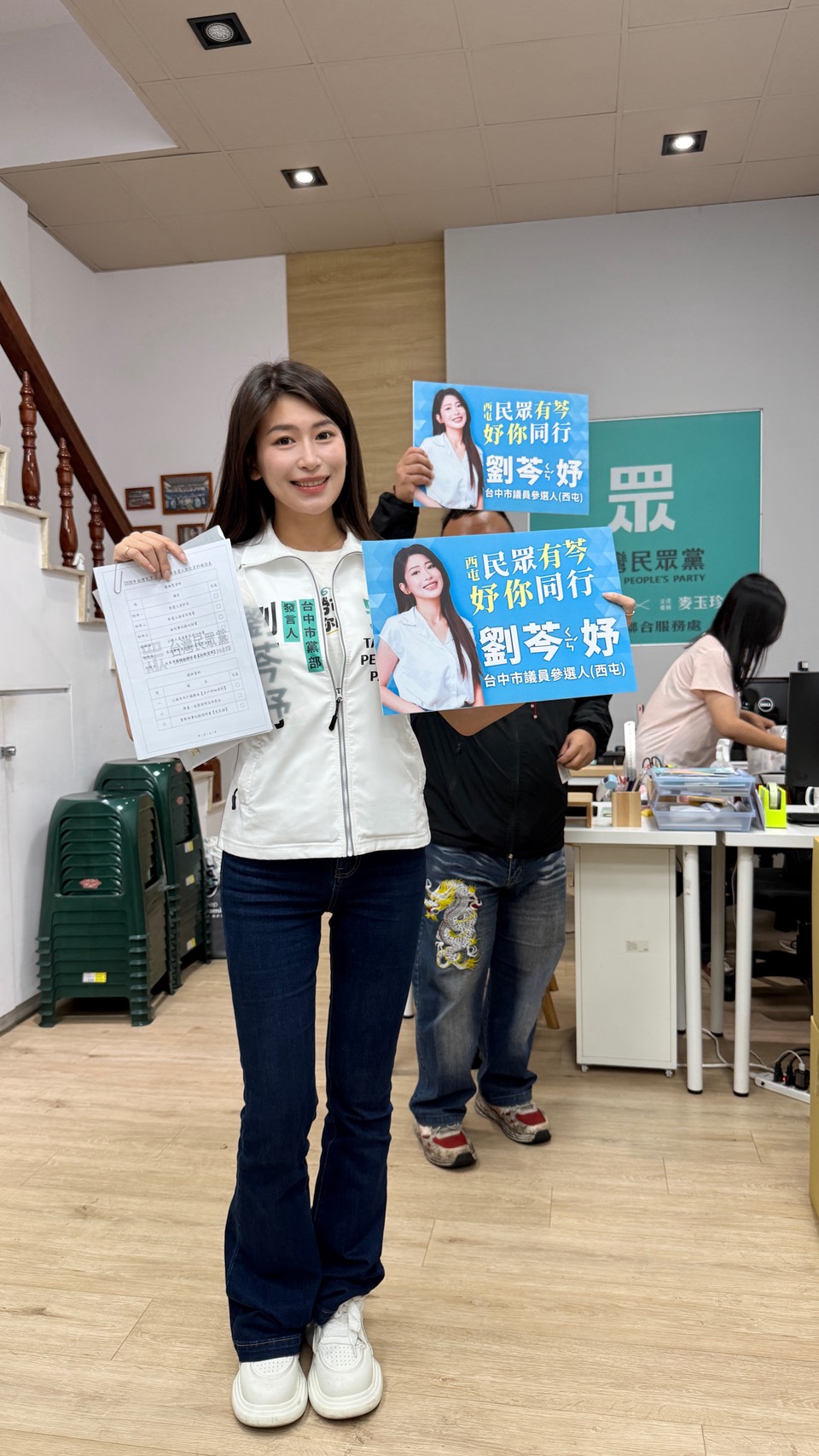 劉芩妤於民眾黨台中市黨部完成參選登記，手持文件與競選看板向支持者展示參選決心。