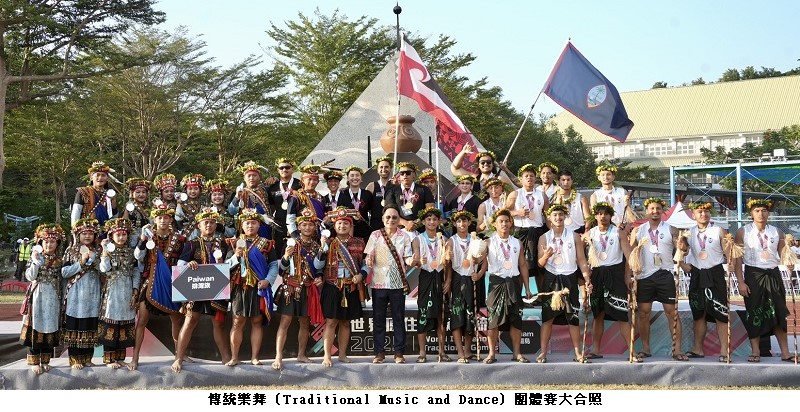 可能是顯示的文字是「 Paiwan 總運速 Vor 傳統業舞 (Tradi (Traditional tional Music and Dance) 團體賽大合照」的圖像
