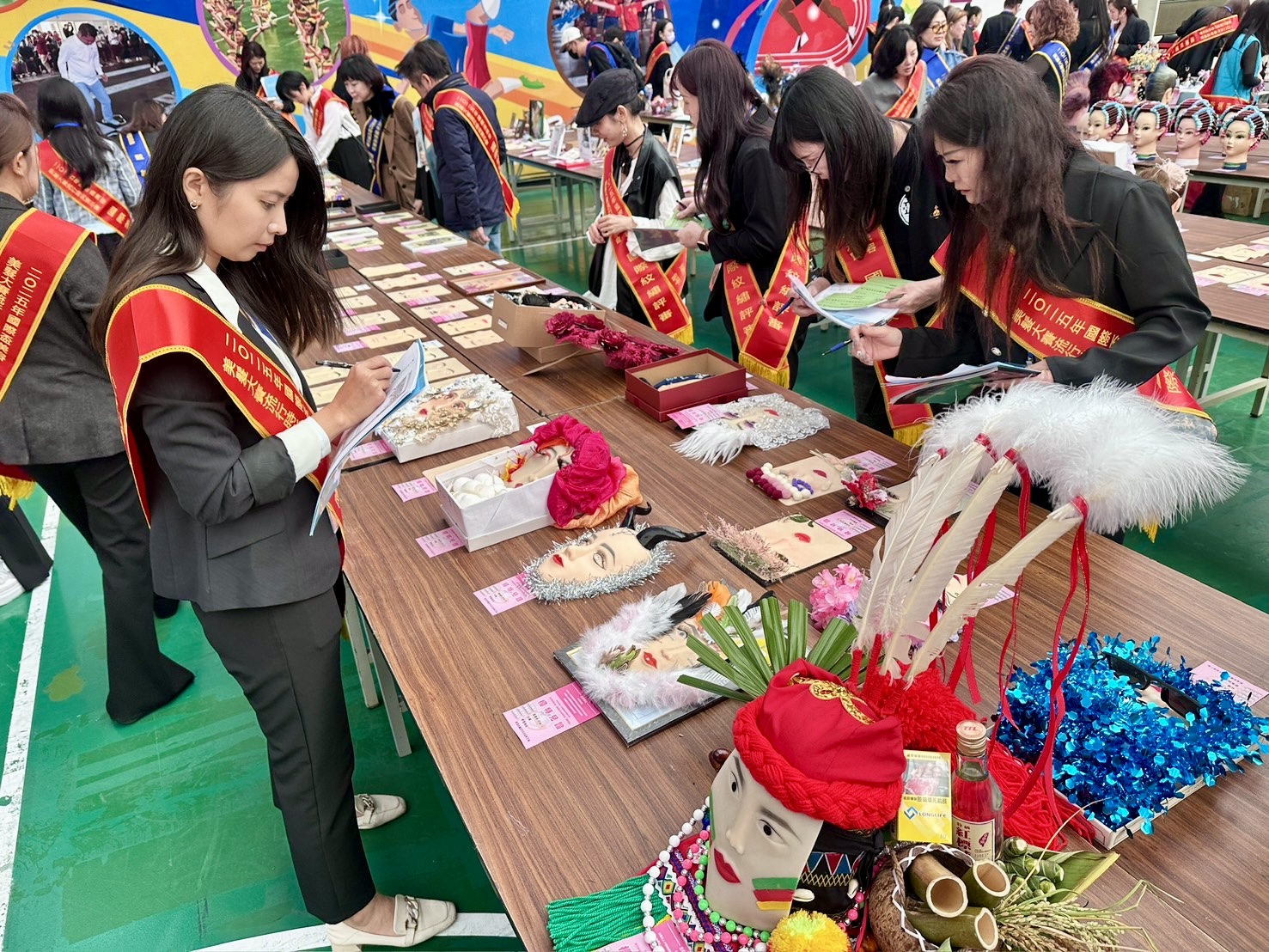 國際盃美容美髮大賽競賽現場,評審團仔細檢視選手作品細節,從造型結構、創意巧思到整體完成度逐一評分,展現賽事專業與嚴謹。(圖/記者林照東攝)