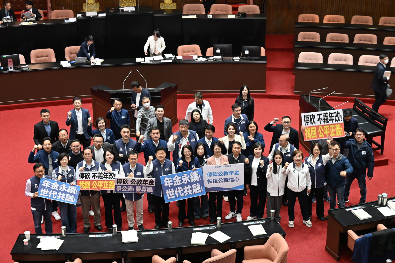 立法院三讀通過公務人員退休資遺撫卹法第三十七條修正案以及公立學校教職員退休資遺撫卹法第三十七條修正案，國民黨團舉牌慶祝。(圖／黃仁國會辦公室)