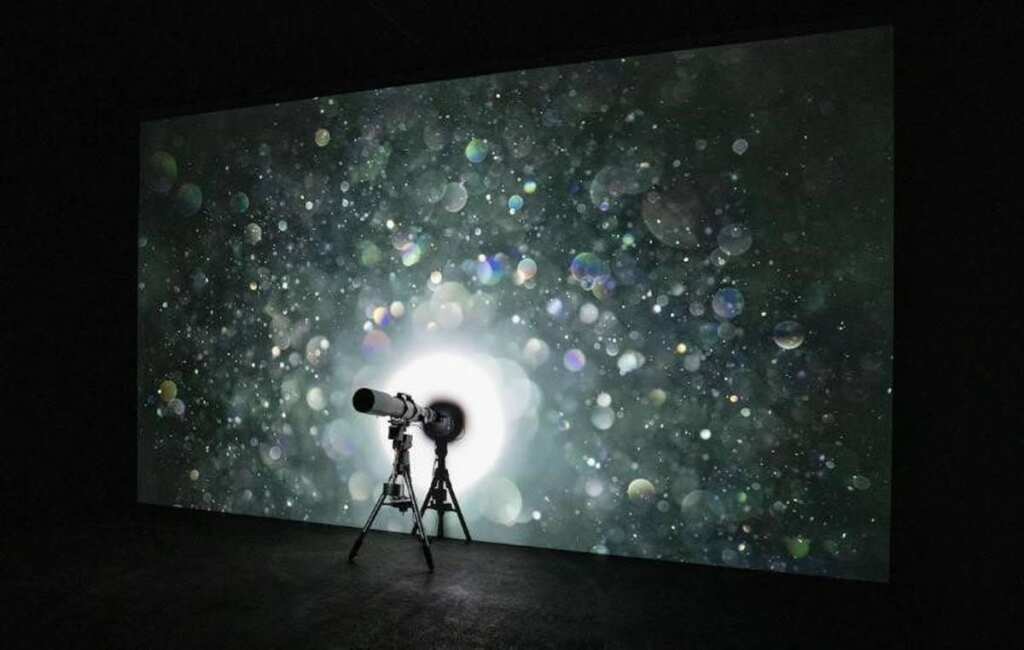 ▲臺北天文館「光的間質」特展以巨幕呈現藝術家吳季璁的作品「灰塵002」。當閃爍的灰塵影像隨著觀眾帶來的變化不定時，瞬間創造出藝術家與觀眾、科技與機遇之間令人著迷的連結。