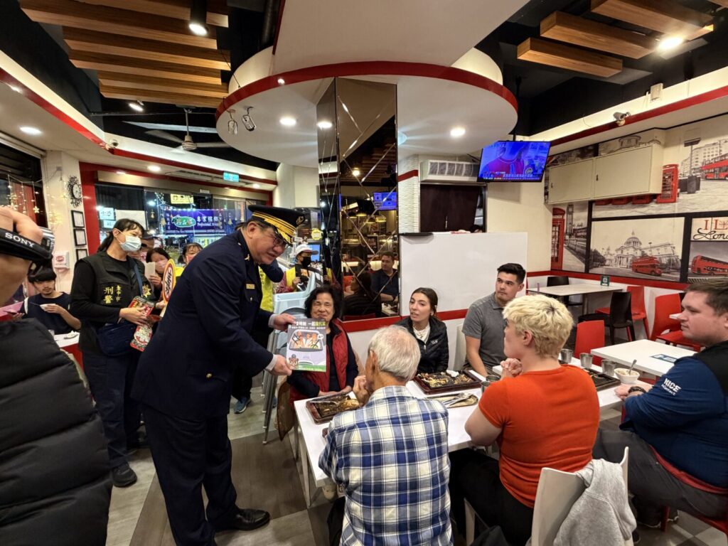大甲分局分局長蔡期望，走進餐桌向民眾及外籍旅客進行防詐與酒駕防制宣導，互動氣氛熱絡。（圖／記者林家嘉翻攝）