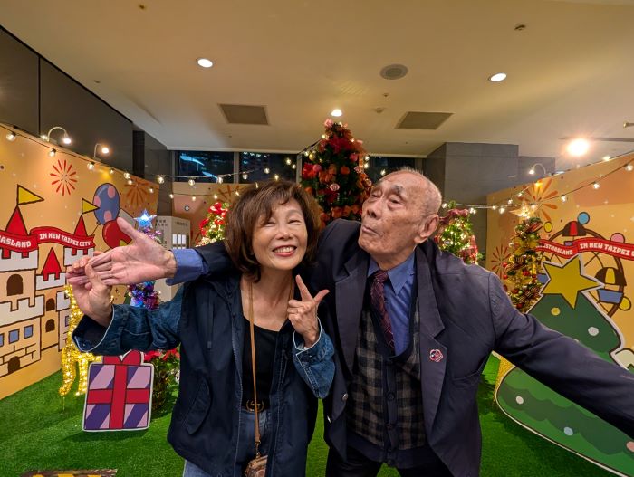 專車夜遊耶誕城 板橋榮家近百歲長輩樂如孩童 35 《圖說》百歲許伯伯穿著帥氣,調皮與板橋榮家陳桂美主任合影。〈板橋榮家提供〉