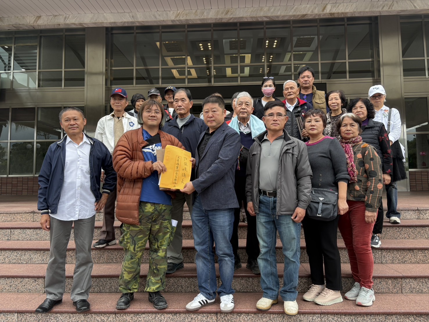 張峻(左三)接下20 多位鄉親代表親自遞交的 約 1,500 位鄉民連署的陳情書。(圖/記者 趙靜姸翻攝)