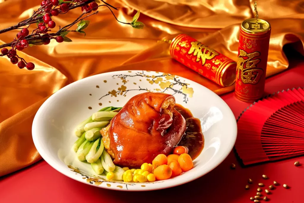 「鴻運醬燒大圓蹄」以特製醬汁慢火燉煮，使蹄皮彈滑、肉質入味，醬香濃厚、膠質飽滿，口感溫潤富層次。(瀚寓酒店提供)