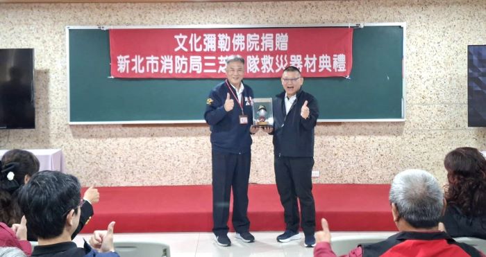 新北消防增添救災能量 文化彌勒佛院捐贈搶救器材 21 《圖說》新北市政府消防局張易鴻主任秘書代表消防局回贈三芝文化彌勒佛院消防公仔。〈消防局提供〉