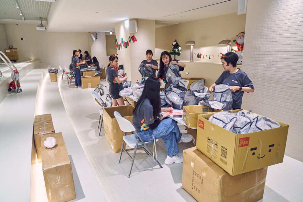遠雄志工們以流水線作業方式,分工包裝耶誕禮物。(圖/遠雄文教公益基金會提供)