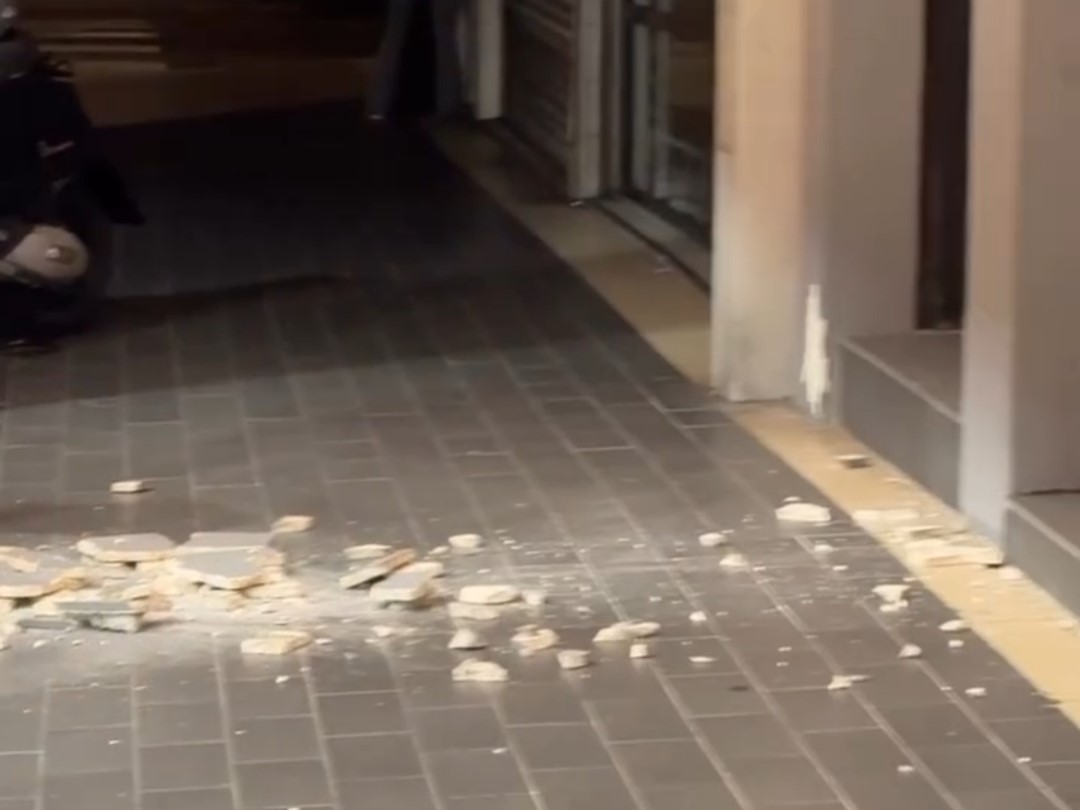 強震造成店門口柱子的外牆磁磚大量剝落,碎塊散落在人行道與騎樓地板上。