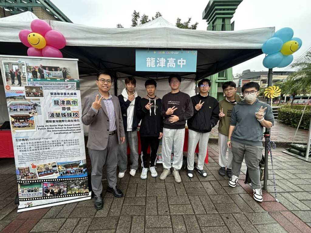 ▲龍津高中校長、組長帶領五位學生在攤位前展現龍津高中雙語教學的成果。(記者林明佑翻攝)