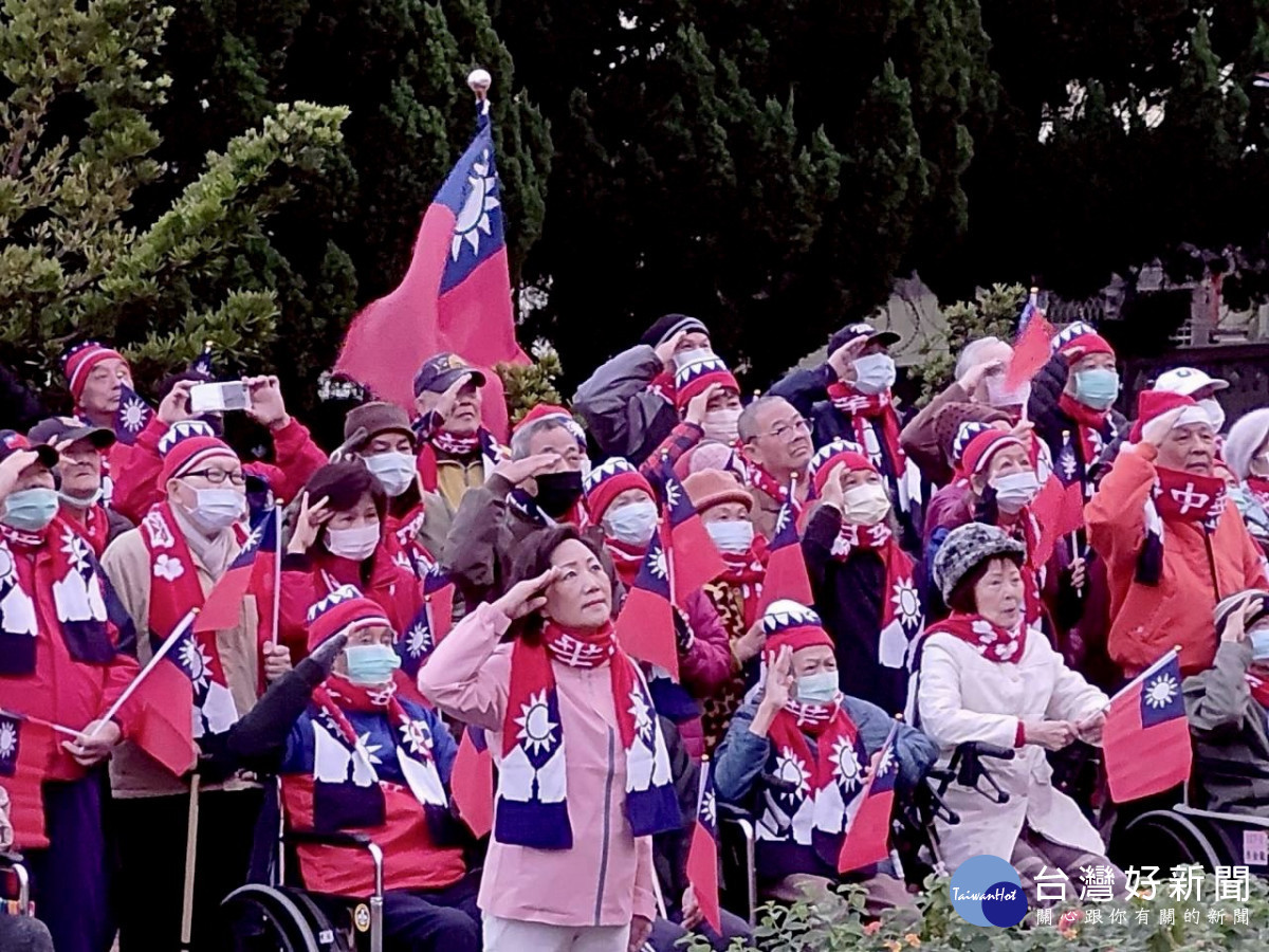 榮家主任白恩惠(前中)帶領住民長輩向冉冉上升的國旗致敬。