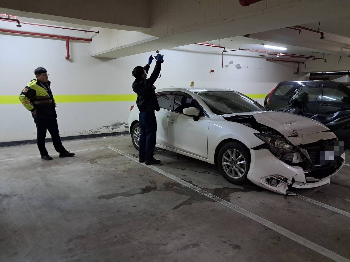 警方於淡水區新民街某社區地下停車場內找到1輛白色轎車，其車頭部位有嚴重撞擊痕跡且毀損嚴重，研判即為涉案車輛。