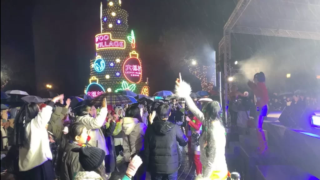 跨年夜細雨中,六福村中央魔術廣場依舊人潮滿滿,遊客撐著雨傘揮舞雙手,跟隨HOt SHOCk 樂團演出熱情互動