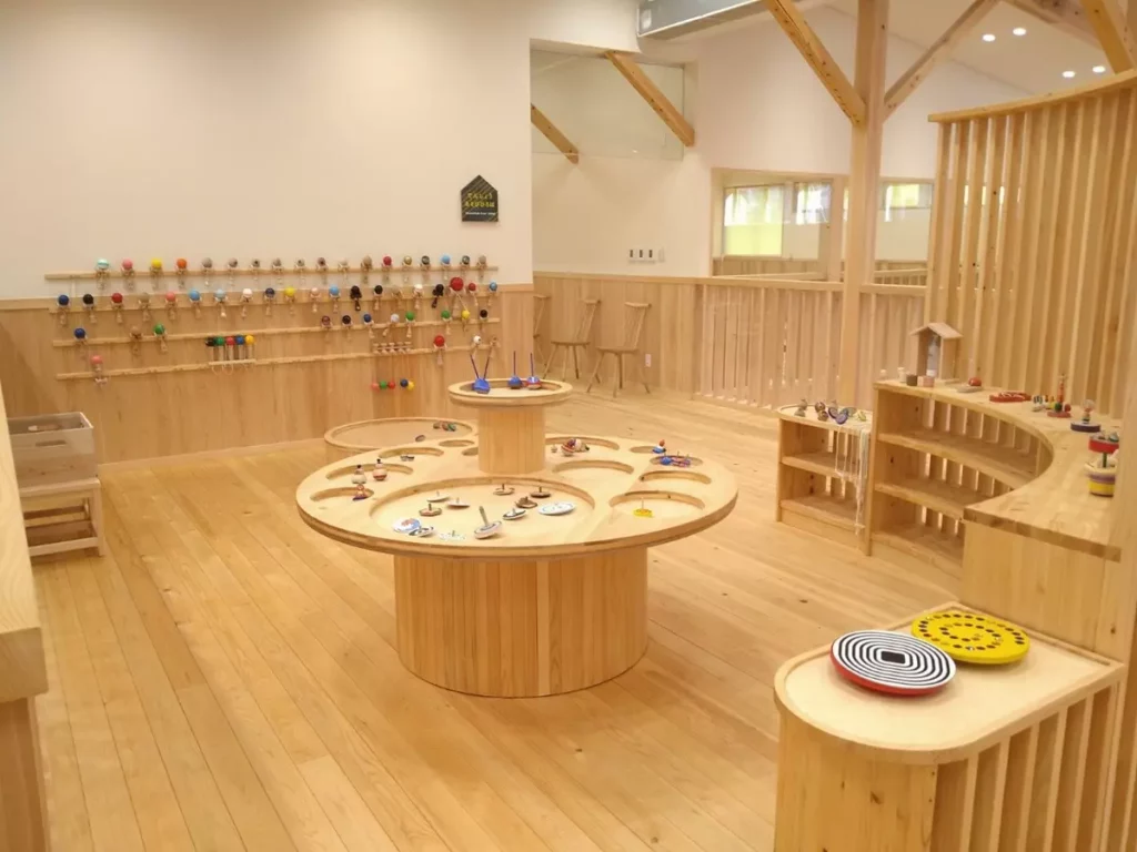 木製圓桌與多樣化的遊具器材,展示各種木質玩具,在安全環境中盡情動手探索與學習。©檜原森のおもちゃ美術館