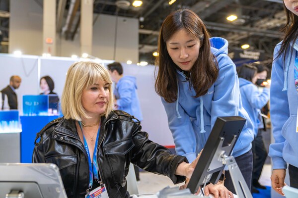 A visitor at the Kolmar Korea booth listens to an explanation of the company’s AI-based technology during CES 2026.