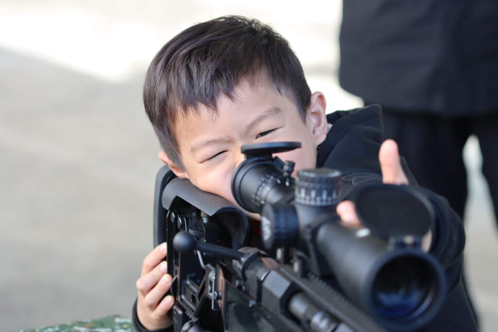 小學生開心體驗憲兵特勤隊的狙擊槍。 (魏冠中攝影)